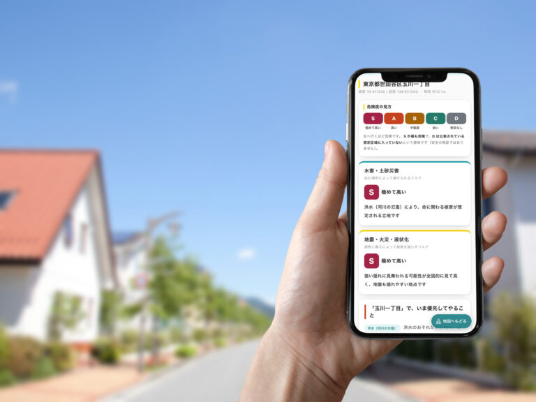 住宅街の通りで、ソコ調の判定結果を表示したスマートフォンを手に持っている